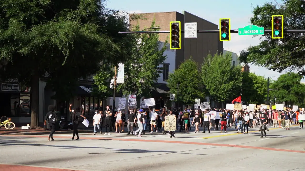 Black lives matter protestors marching down the city streets with signs in peaceful rally