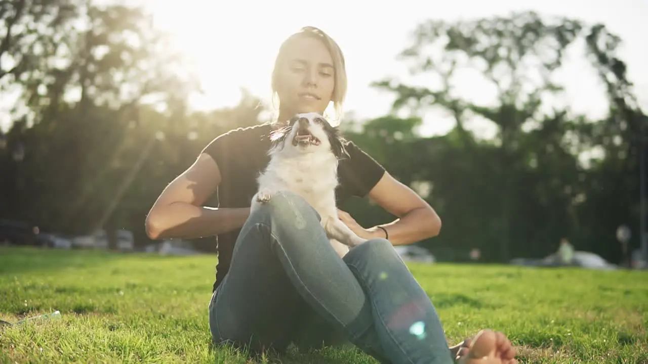 Young Beautiful Girl Sitting On The Grass With Her Dog