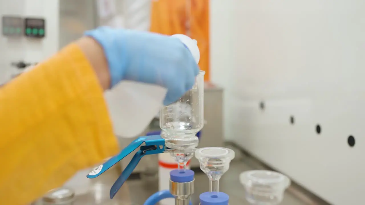 Scientist rinsing a beaker with water after an experiment