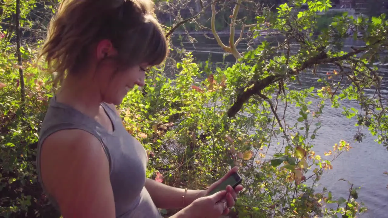 Cute hipster girl candidly laughing dancing and talking while looking at her green screened phone