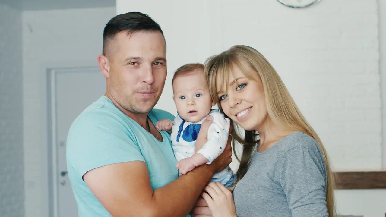 Portrait Of A Happy Family Mom Dad And The Son Of Two Months Looking At The Camera Smiling