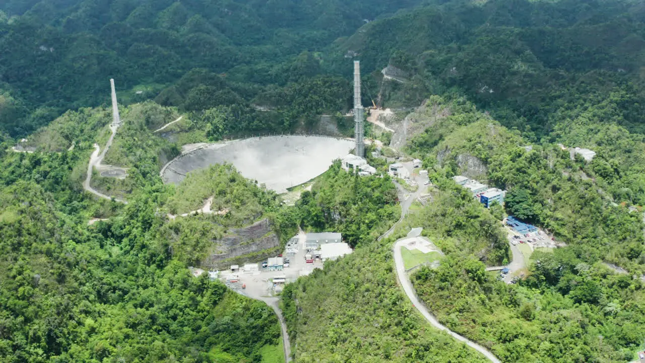 Reveal of partially deconstructed parabolic antenna at Arecibo Observatory Puerto Rico slide left