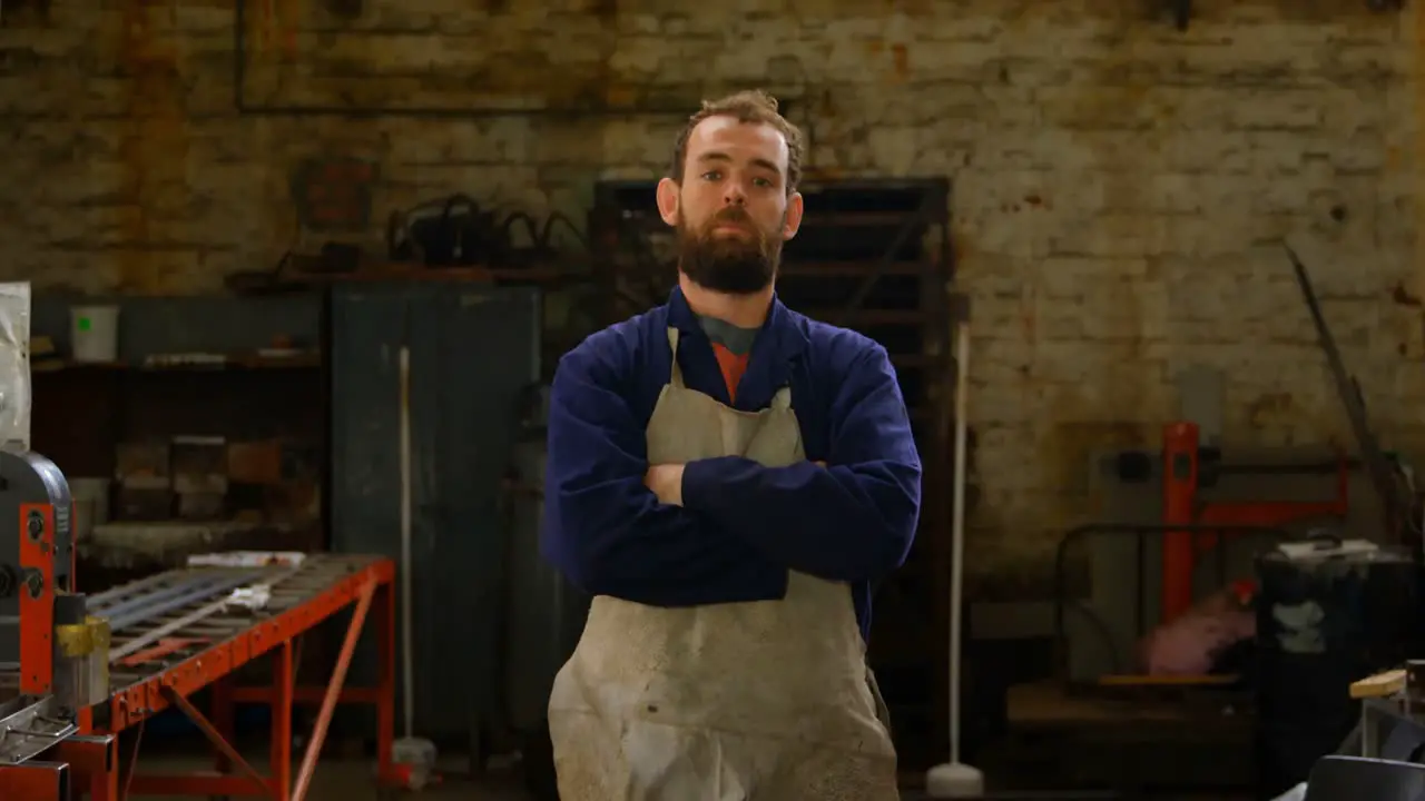 Metalsmith standing with arms crossed in workshop 4k