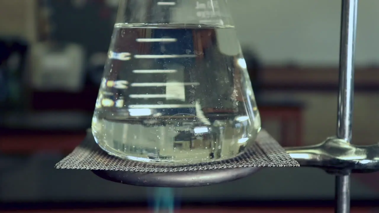 Erlenmyer Flask that is being heated by a bunsen burners no condensation left heat waves visible in flask bubbles forming