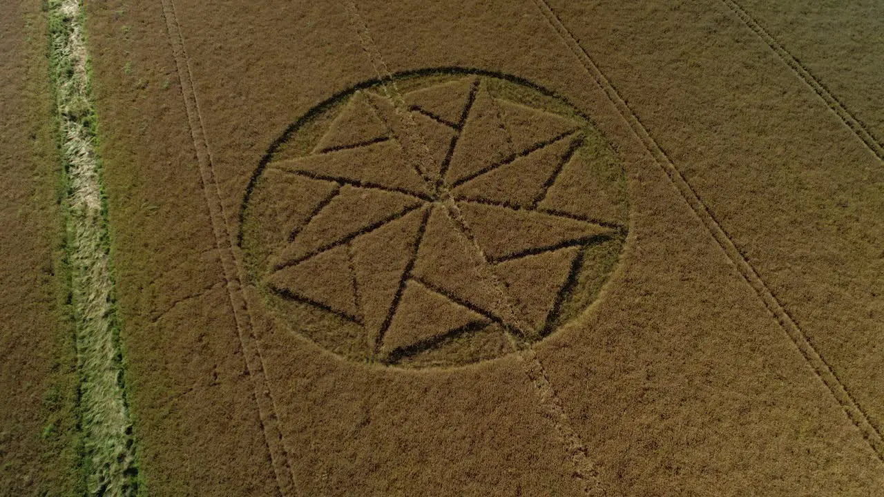 Extraterrestrial farmland crop circle geometry artwork Stanton St Bernard aerial view Wiltshire tilt down drone shot