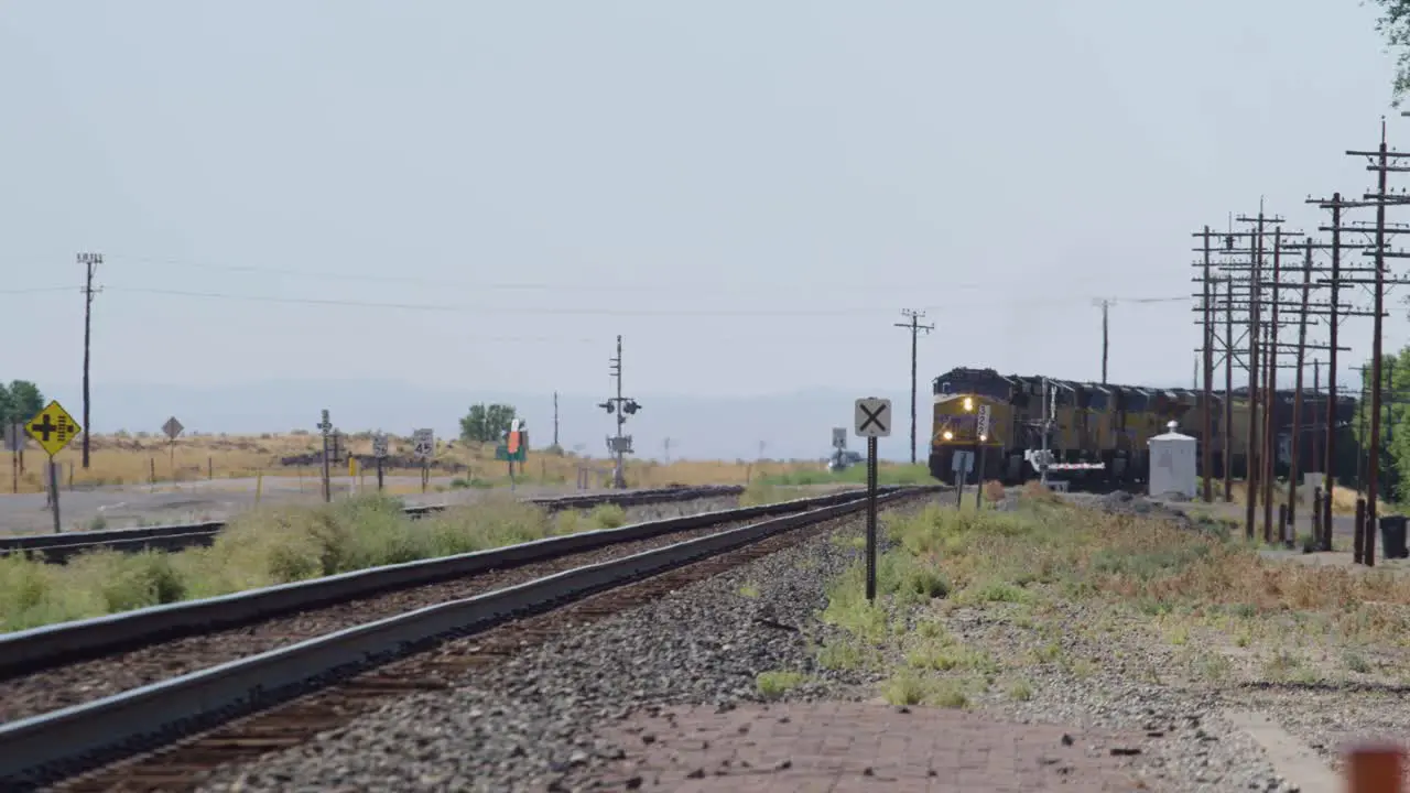 A train travels across the hot Idaho desert in the summer delivering goods to far away places in 4K