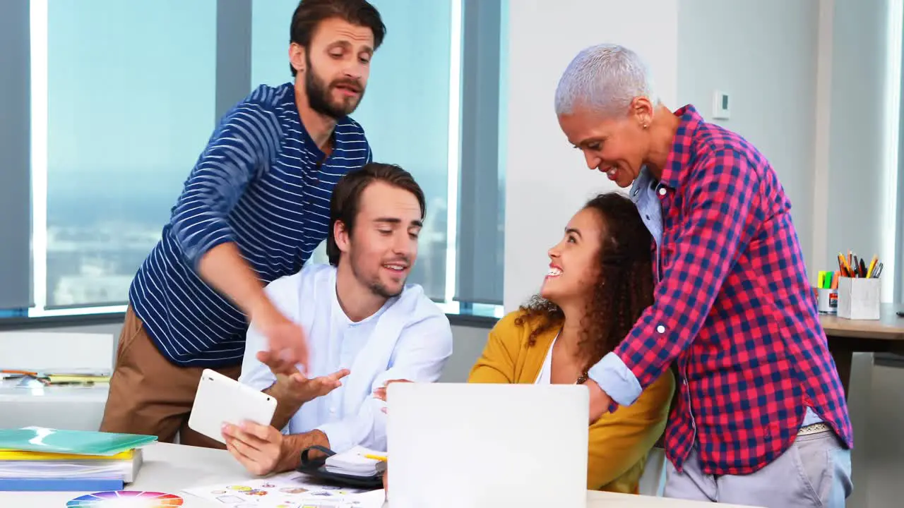 Team of executives discussing over laptop