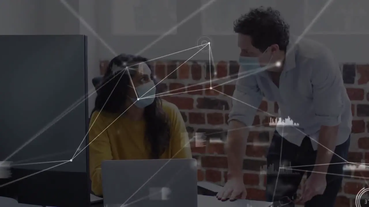 Animation of network and data over diverse colleagues in face masks working in creative office