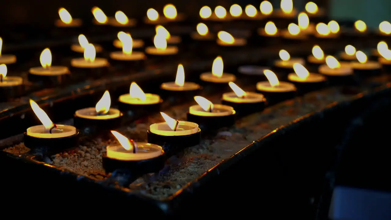 Many burning candles with shallow in church