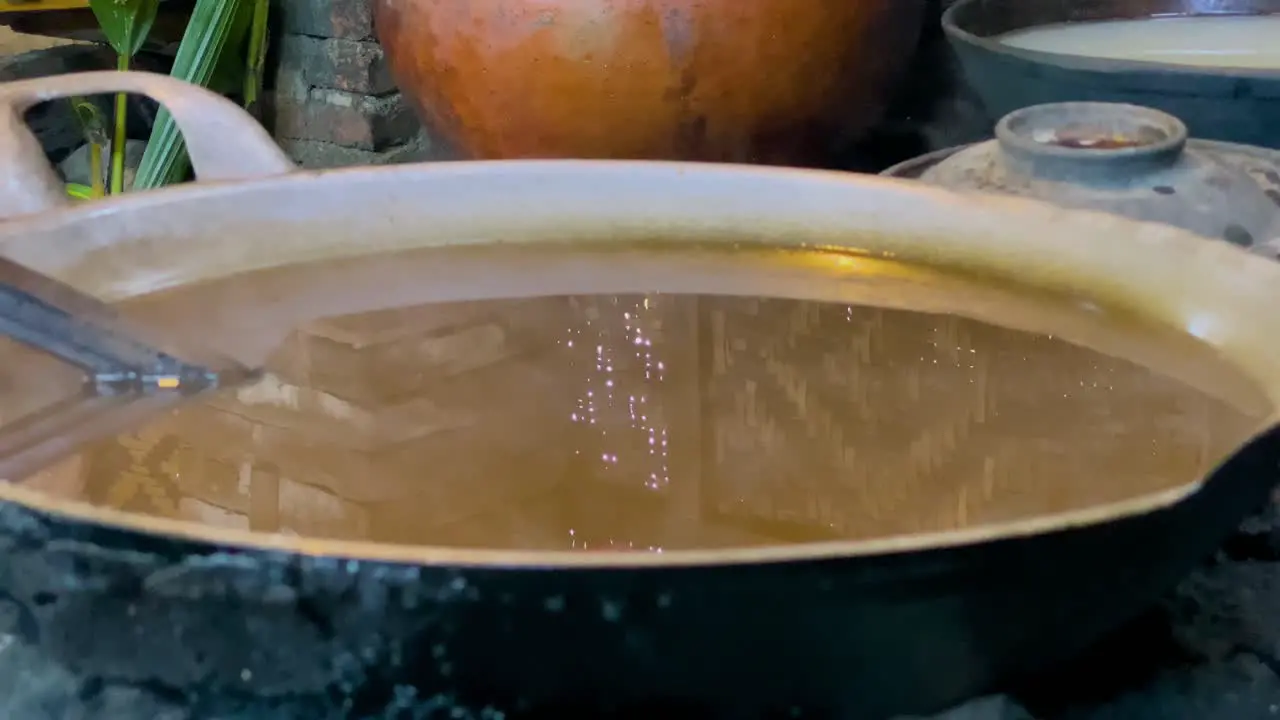 Close up shot of smoky coconut sap boiled on an iron skillet