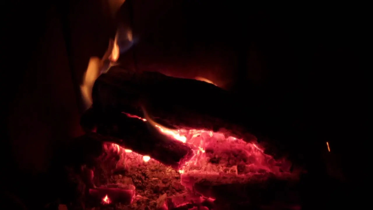 Wood burning fireplace fire in home with large burning hot orange bright flames providing heat to home during winter time surrounded with white ash