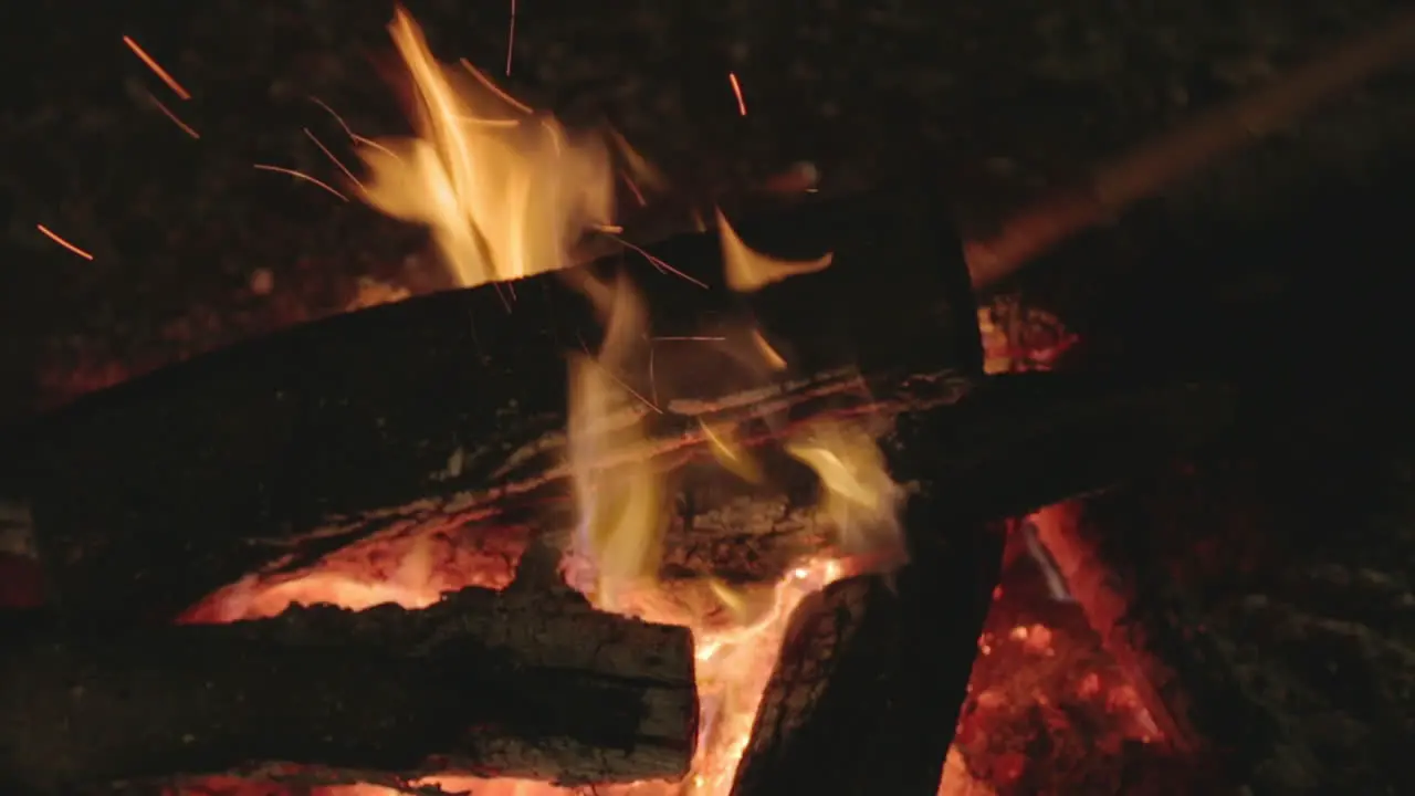 Top shot close up on campfire burning at night with hot charcoal and wood