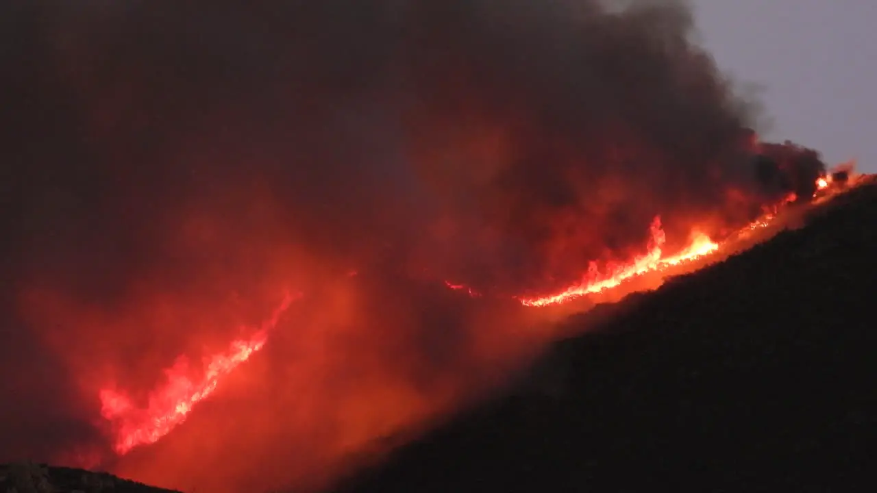 Large and uncontrollable fire in forest on silhouetted