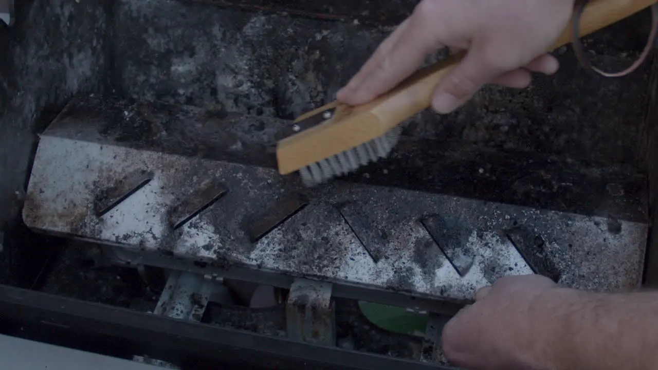 filthy Barbecue being scrubbed clean with metal brush in slow motion