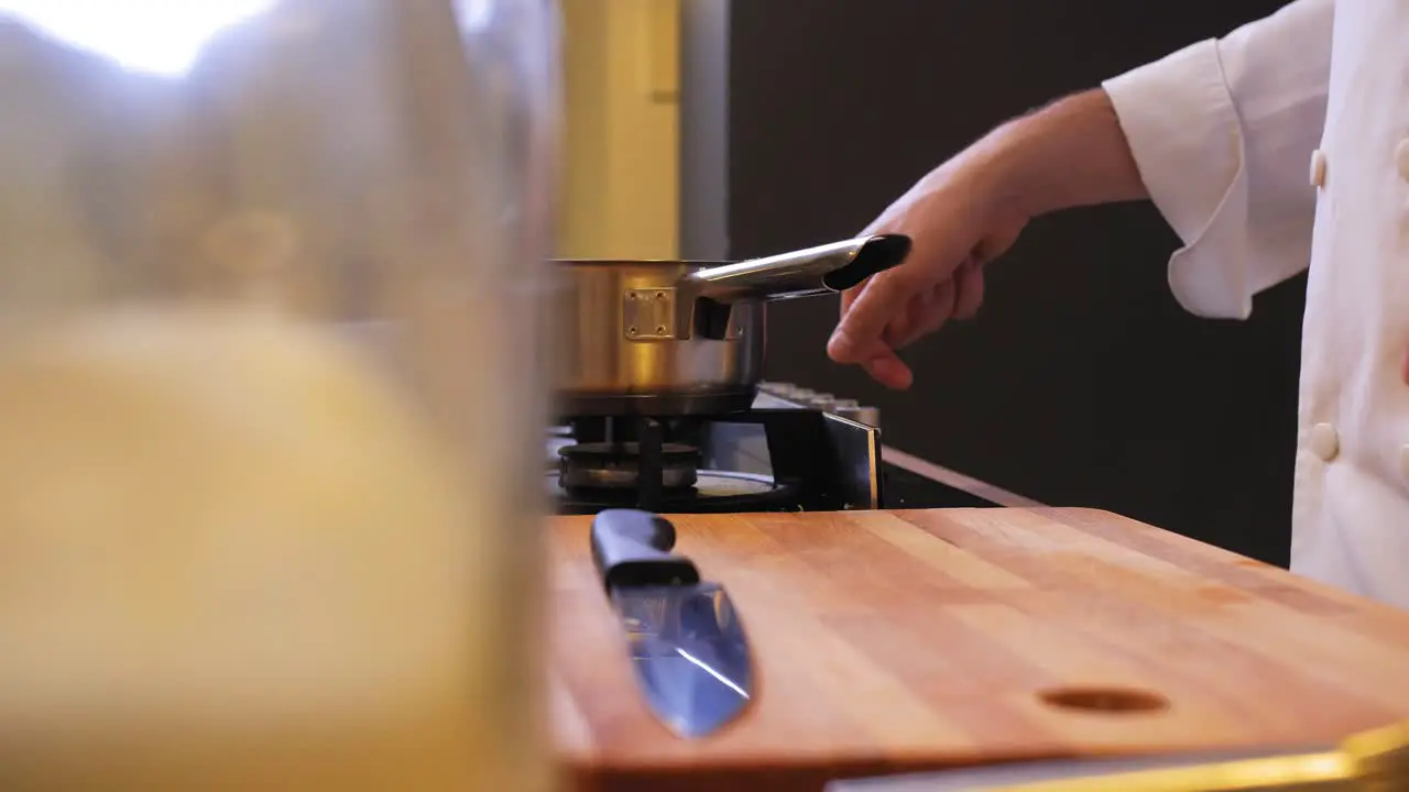 the cook ignites the gas under a pot