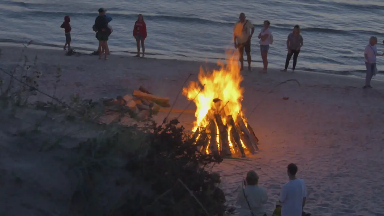 Crowds of People Watch Burning Bonfires on the Beach of Latvia During Sunset