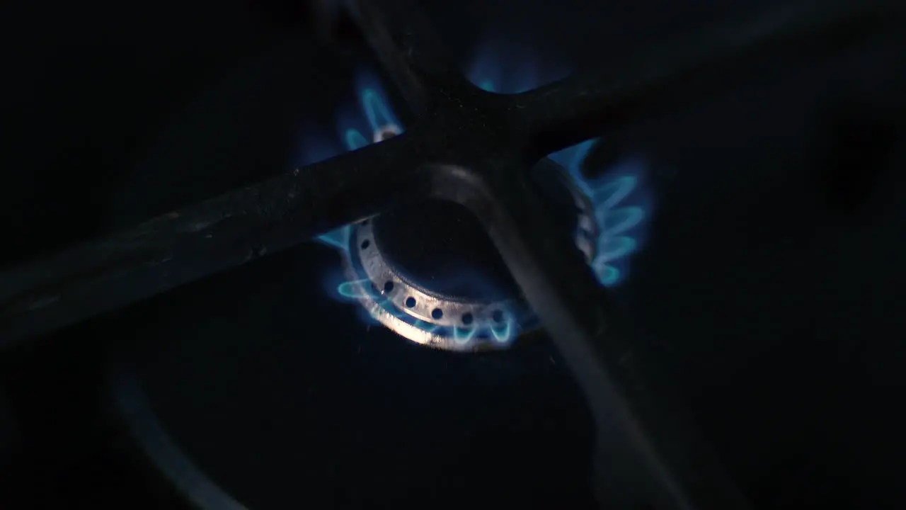 A distorted close up of a small hob on a ceramic gas stove being lit burning for a while and then turning off