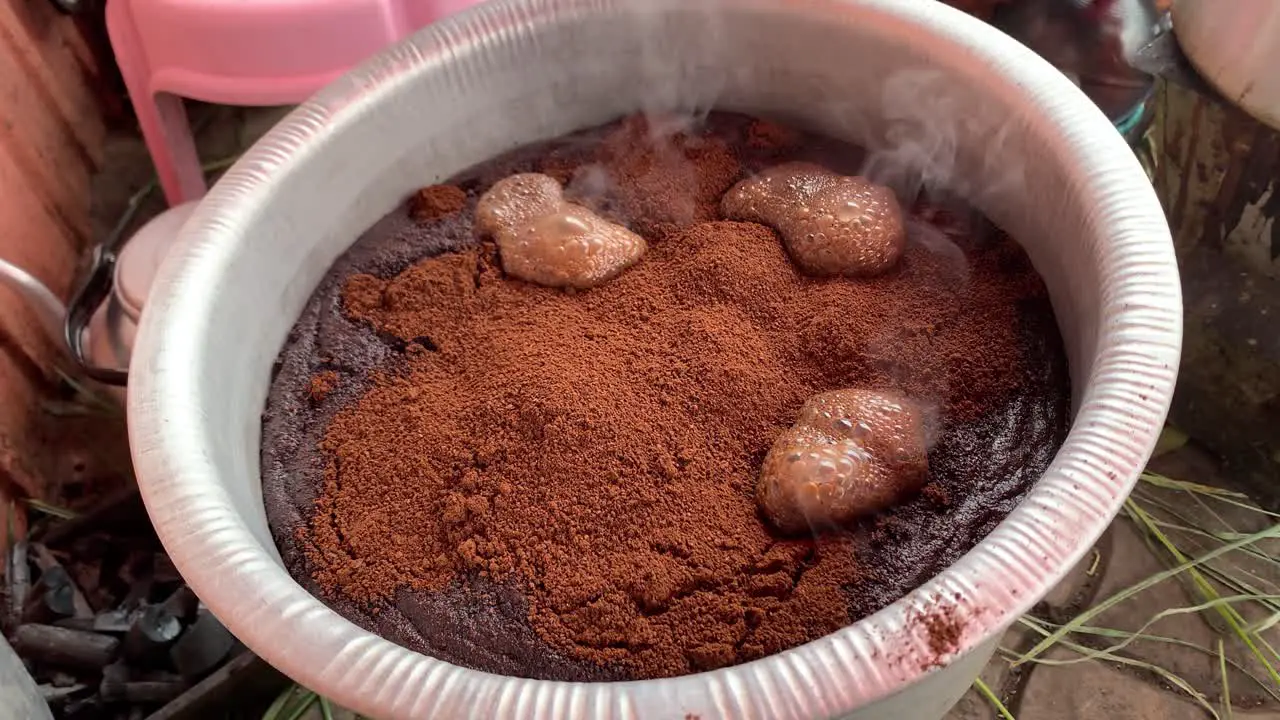 The coffee powder is dissolving and the foam are forming the coffee seller they make big quantity and move it to the Jabana to serve it to customer