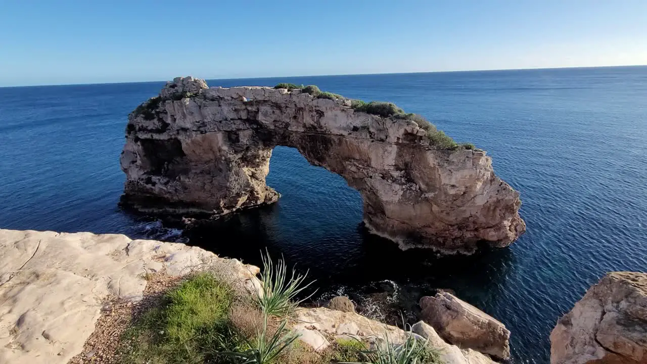 arch-shaped rock formation on the coast of mallorca called es pontas