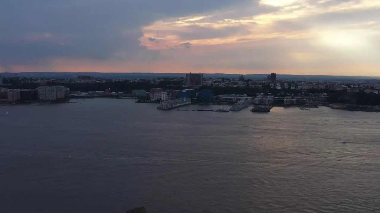 Aerial drone footage pan right looking over the Husdon River near Hudson Yards durring an orange sunset