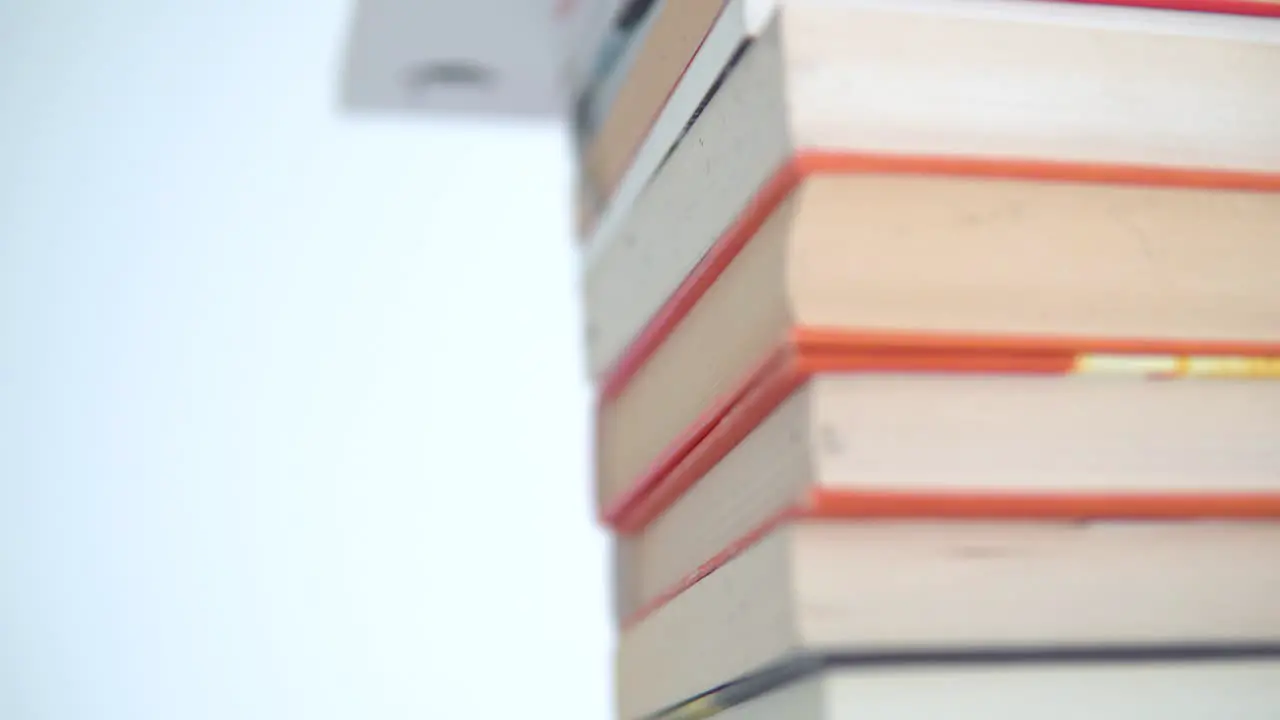 A stack of books with colourful covers is on the table