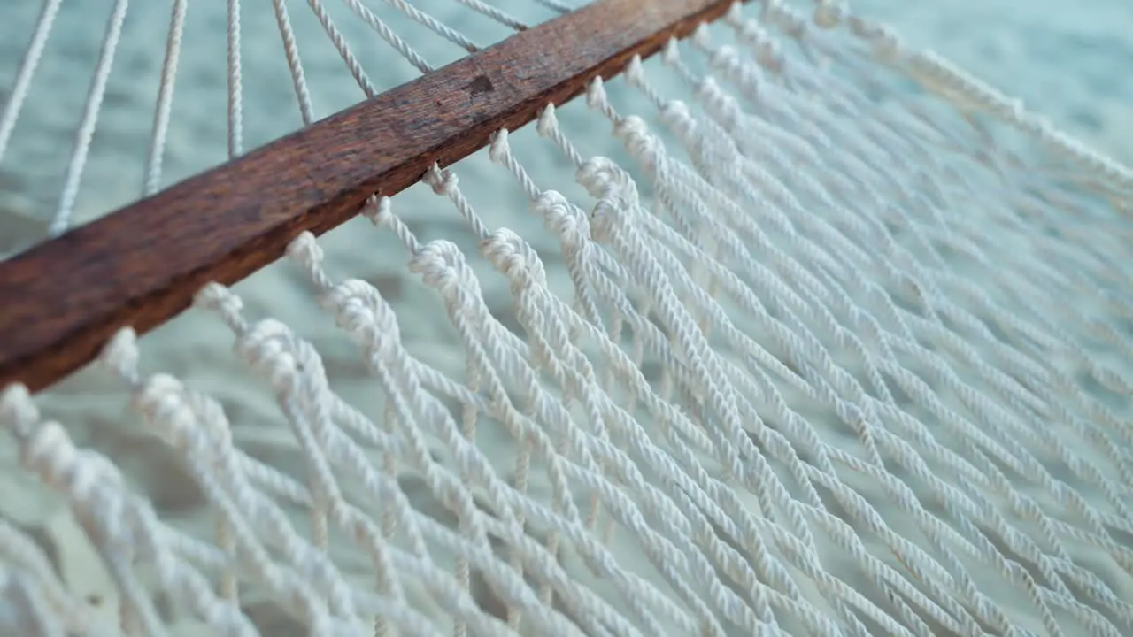 Hammock swinging with wind breeze in sandy summer resort close up