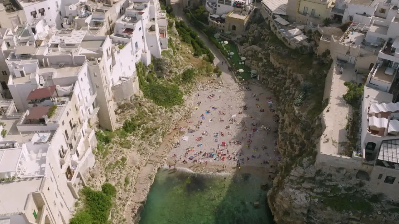 Aerial footage of Lama Monachile beach in Polignona a Mare Italy with beachgoers relaxing