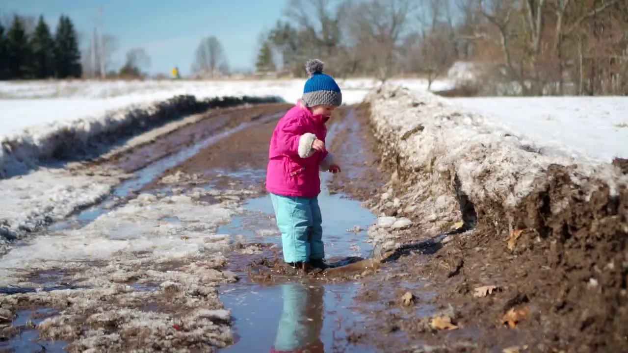 Young Girl Jumps Into Mud Puddle in Slow Motion