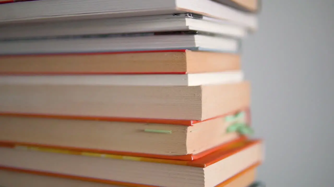 Large close-ups on the edges of books and slow top-to-bottom movement with high depth of field