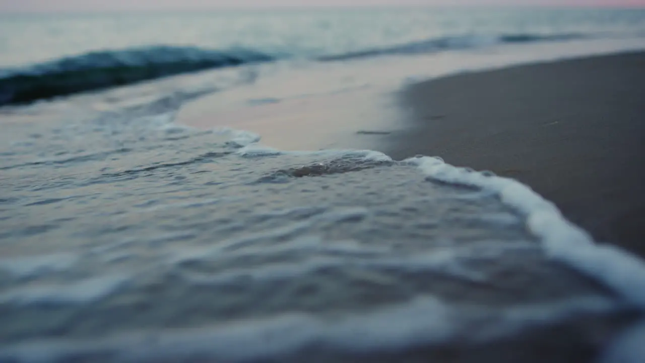 Evening seashore close up Closeup calm ocean water waves splashing sandy beach