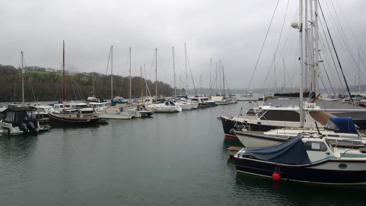 Wide shot in the rain of Boats Yachts Moored Up On The Floating Harbour At Mylor Yacht Churchtown