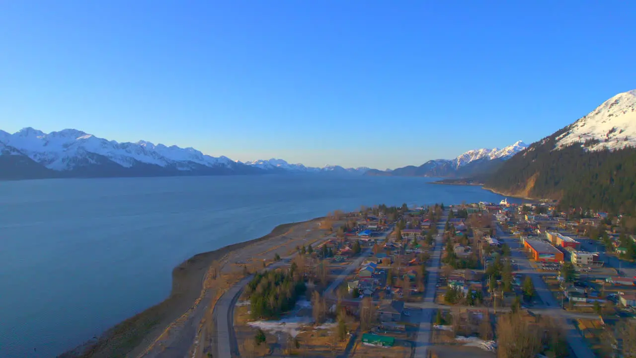 Side to side aerial view of downtown Seward Alaska and the mountains at sunrise