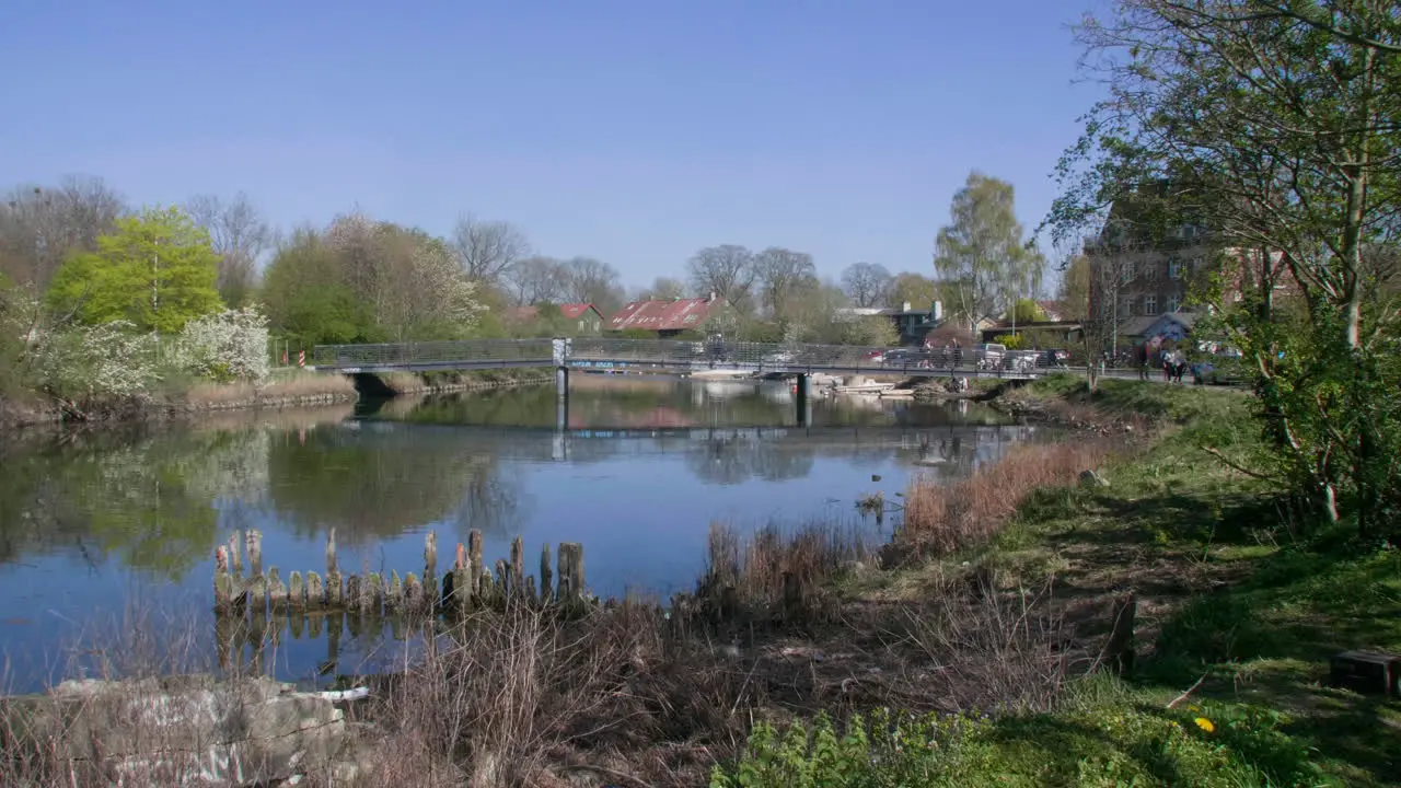 Tranquil river scene with bridge and lush greenery in Copenhagen Denmark near Christiania