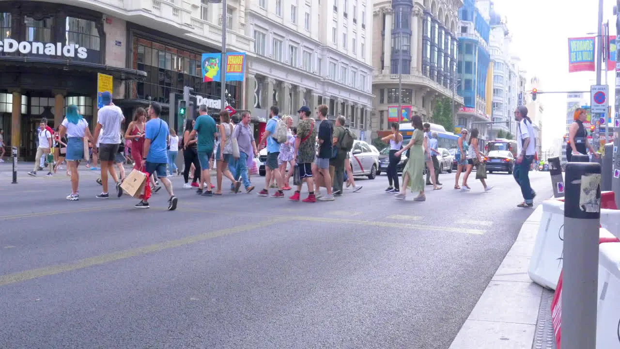 Gente cruzando la Gran Via cuando da la luz verde el semaforo