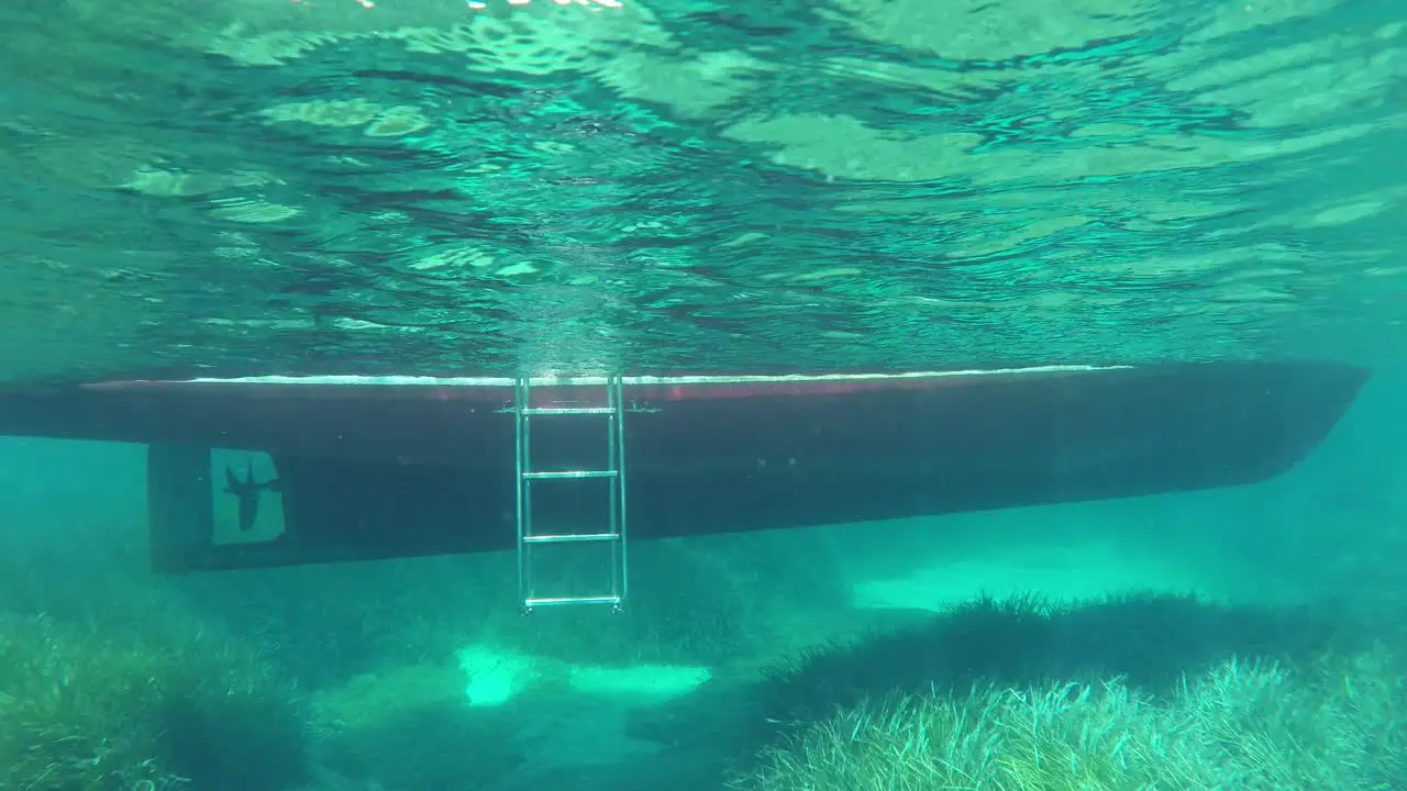 View of a boat underwater below water line in crystal clear water