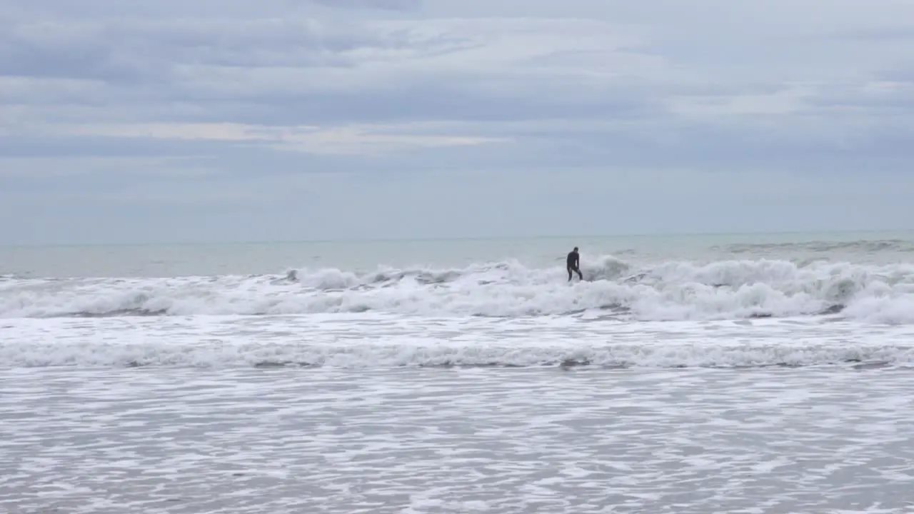 Slow motion of a surfer on a stormy day in the Mediterranean Sea ride the wave with dirty water and gray day