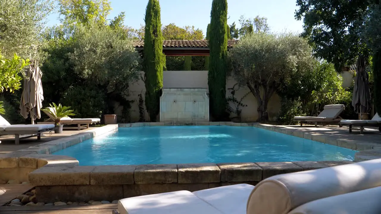 Exterior view of outdoor pool with sunbeds in garden of a luxurious modern castle in southern France