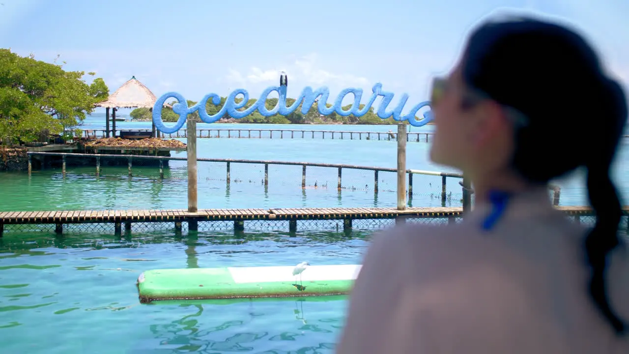 Medium shot of a girl using blue sunglasses staring at the ocean in an Oceanarium in Cartagena Colombia-1