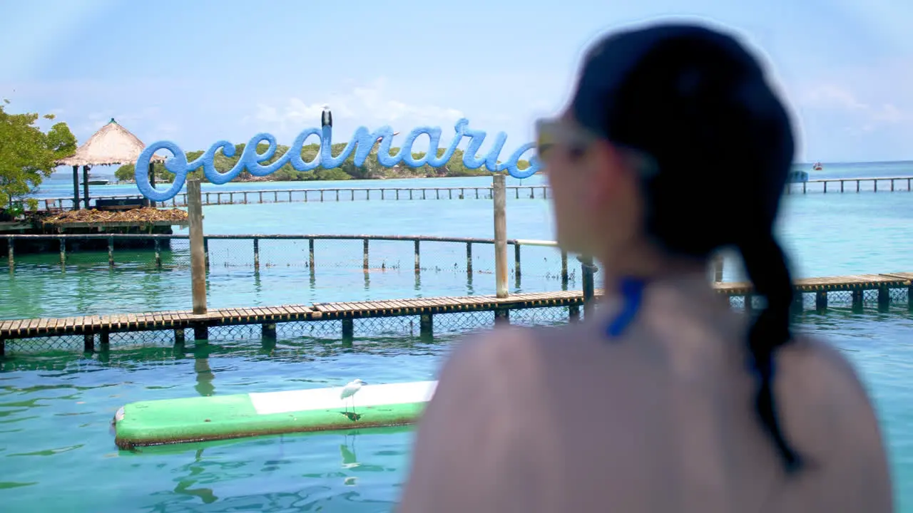 Medium shot of a girl using blue sunglasses staring at the ocean in an Oceanarium in Cartagena Colombia