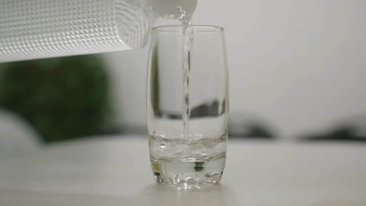 Pouring water into a clear glass in slow motion