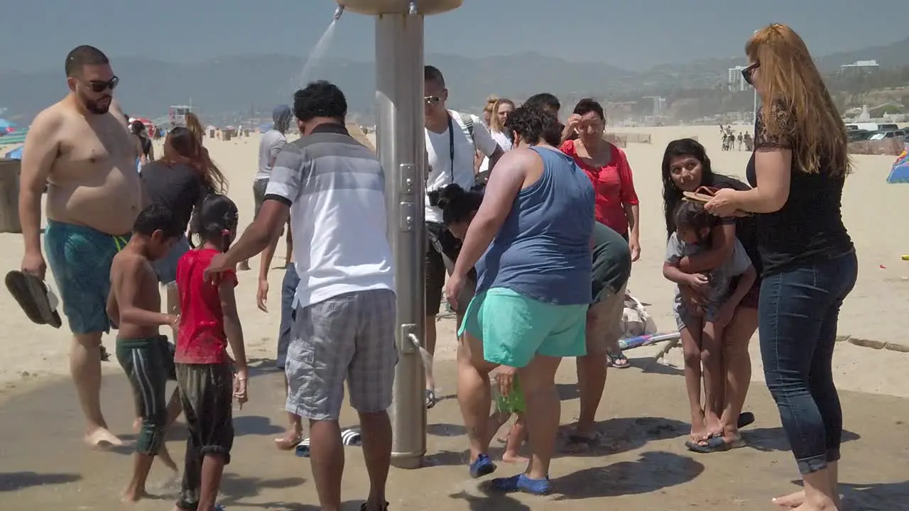 People washing themselves off on the beach in Santa Monica California in slow motion