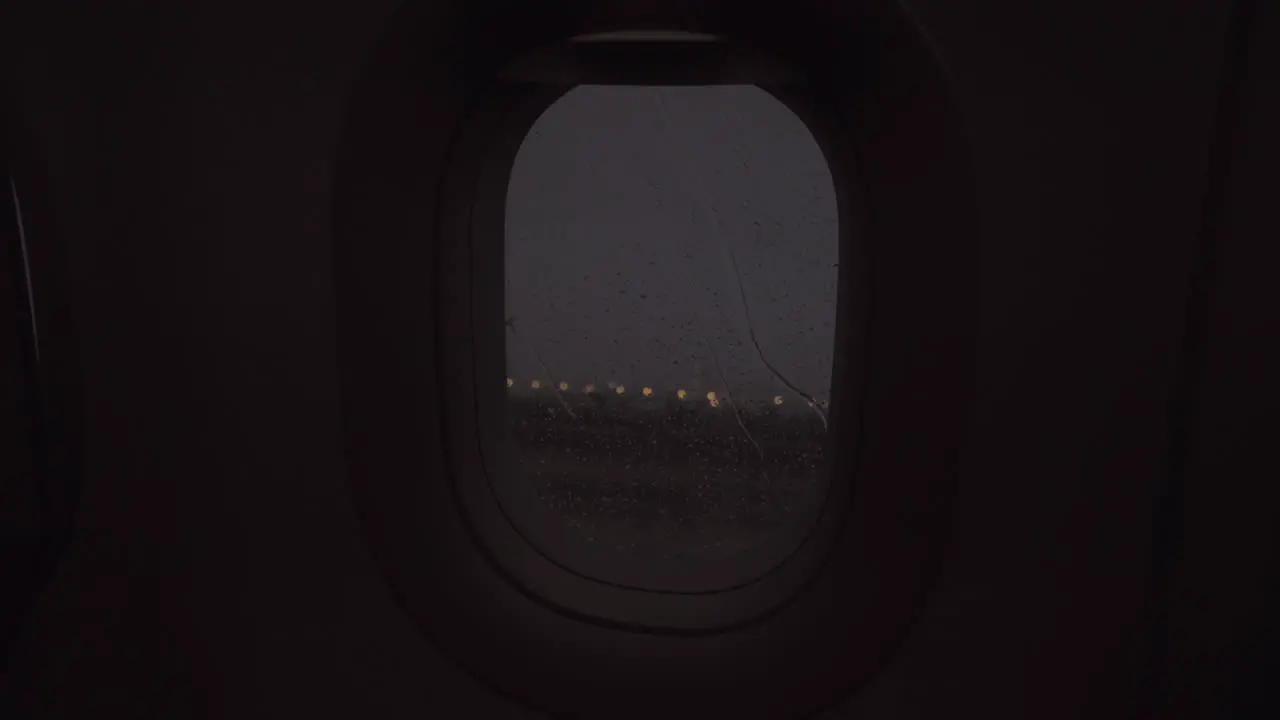 An evening rainy view from an airplane porthole