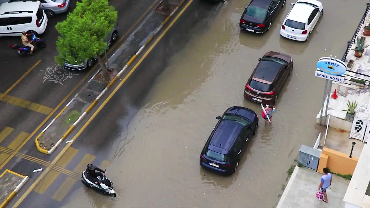 Flooded street and vehicles passing through the sewage after a massive storm in Kusadasi Turkey