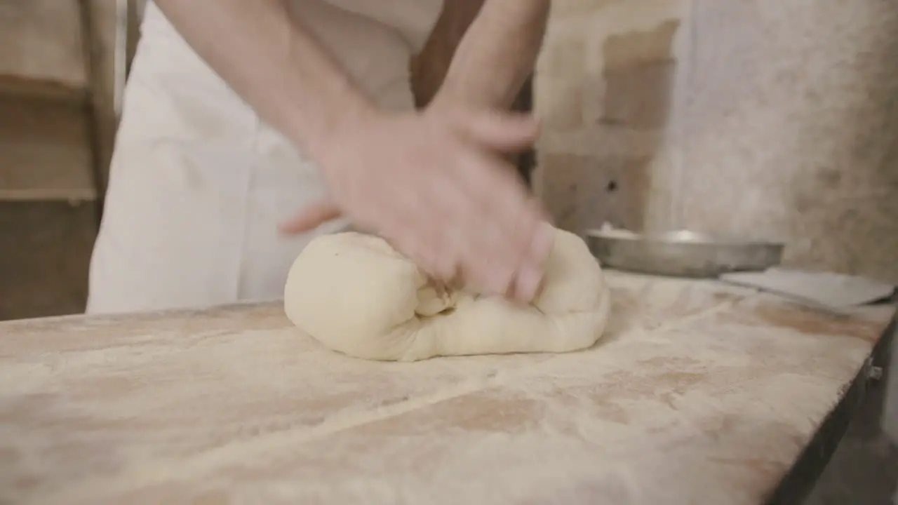 Slow motion footage of a man kneading and folding focaccia dough