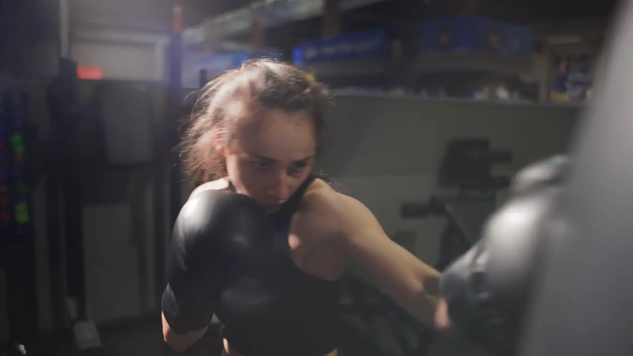 Female Boxer Punching Boxing Bag During Training In Gloves