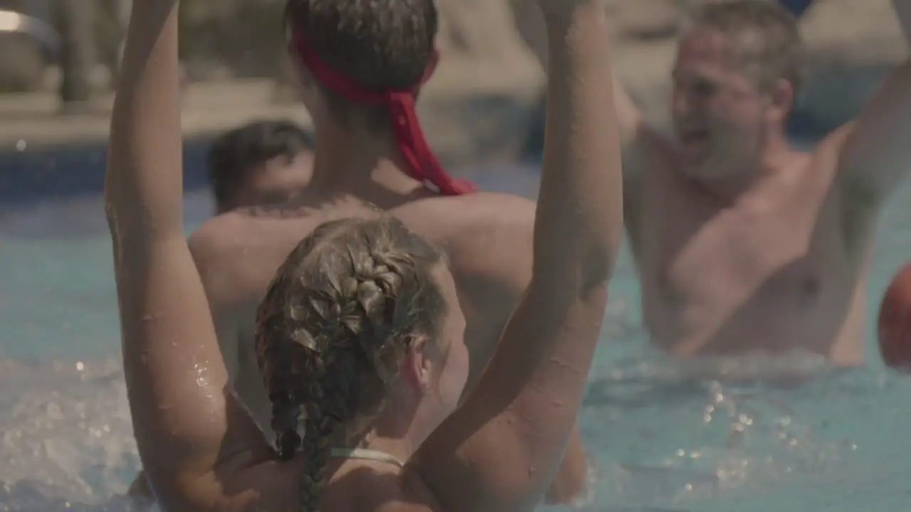 A girl celebrates scoring a goal in the pool