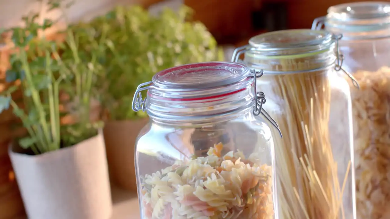 Storage jars of food on countertop in sunny kitchen slow motion