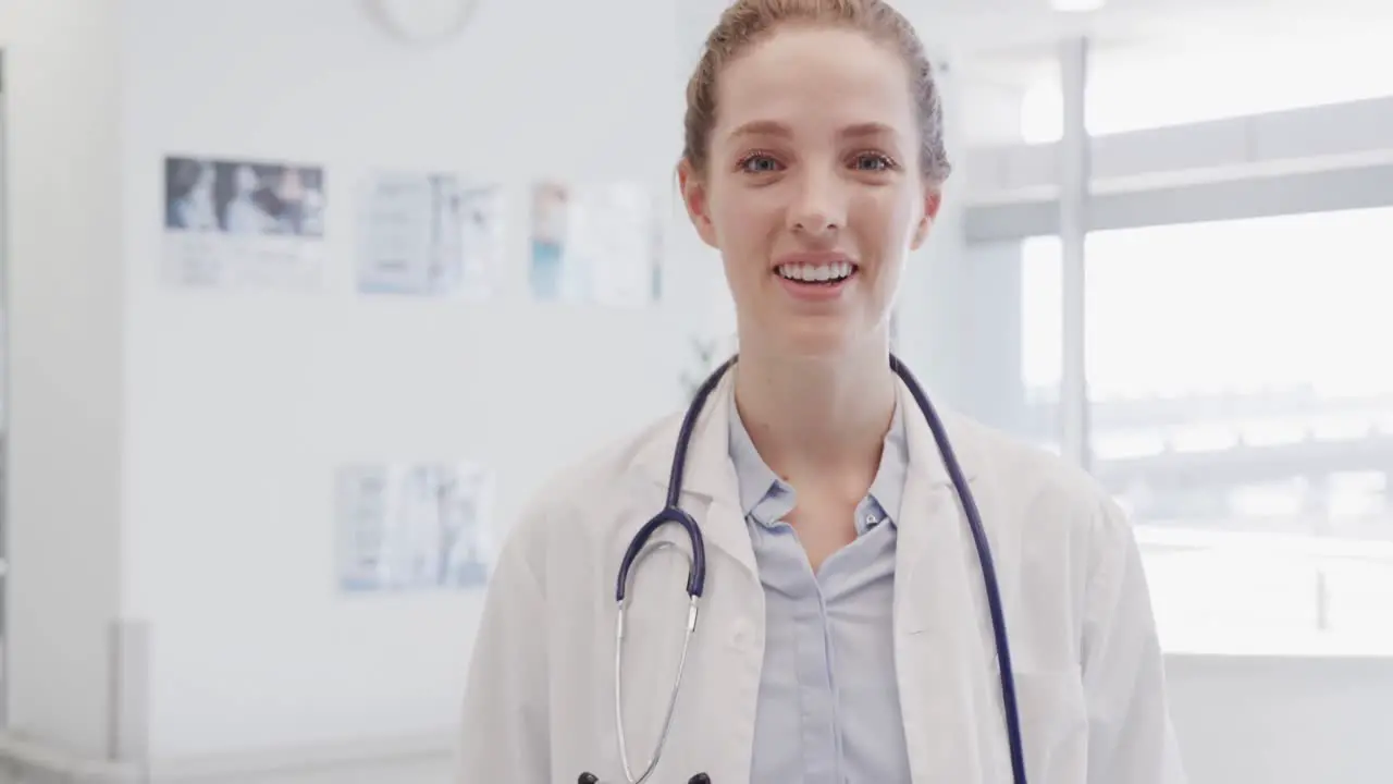 Portrait of happy female doctor with stethoscope smiling in hospital in slow motion