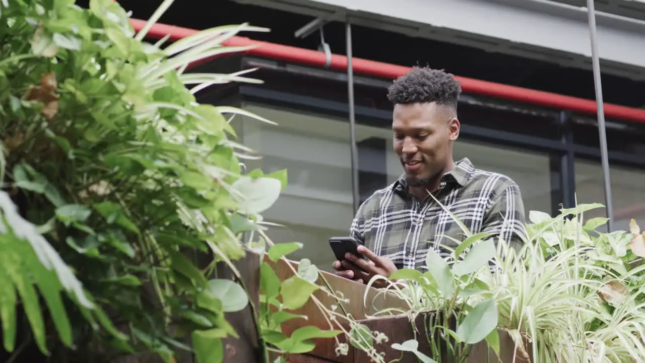 Happy african american male creative using smartphone at casual office in slow motion