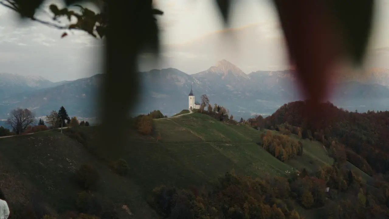 Church on top of a hill with snowy mountains in the background